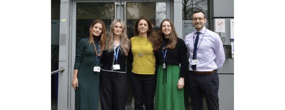 Photo of 5 people standing outside a building