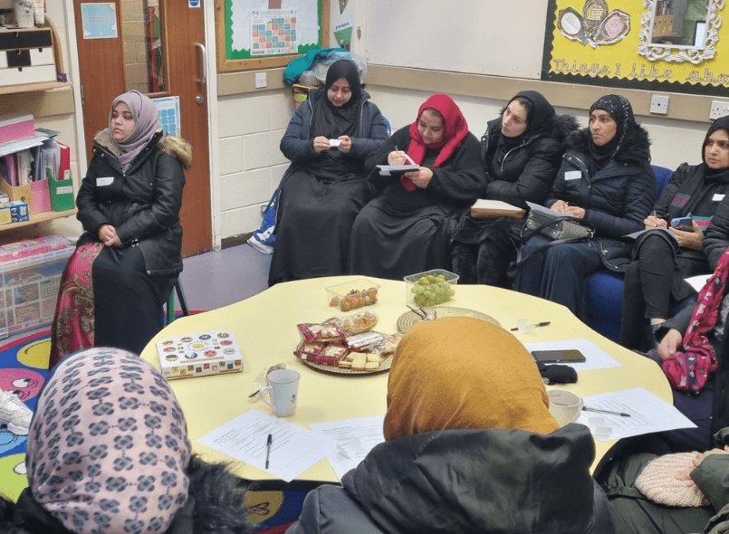 A group of women sat around a table during an outreach session