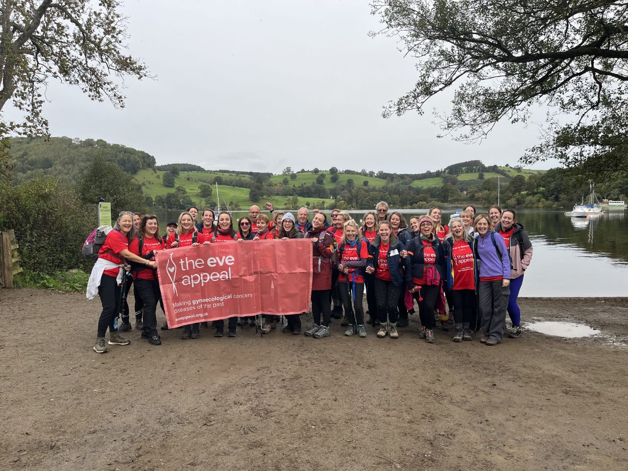 a big group of people at the start line of a trek with an Eve banner