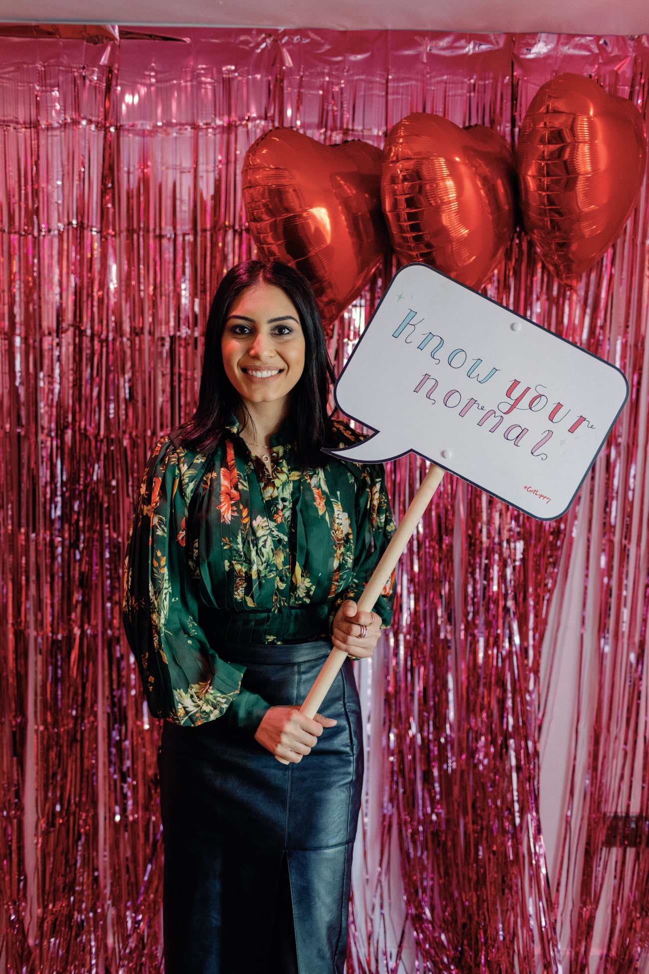 Anila Dhami holding a sign saying know your normal