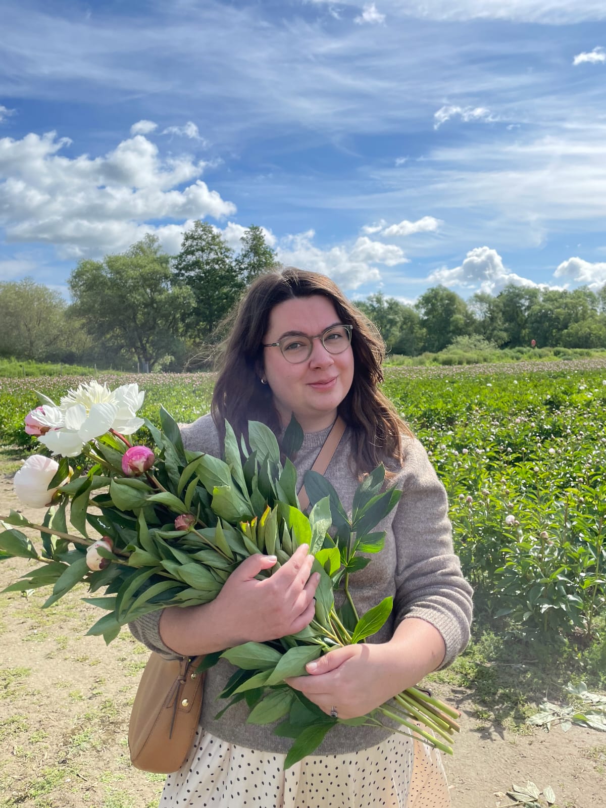 A photo of Eve holding flowers in a field