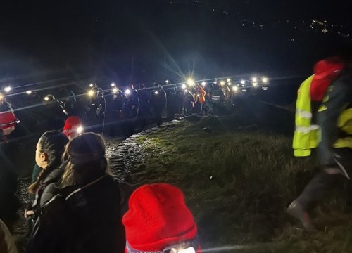 Image of Eve appeal supporters trekking Snowdon at night with torches