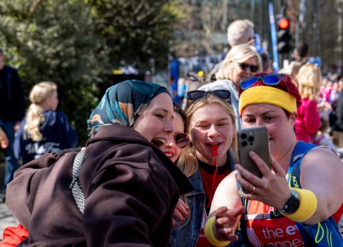 Image of the eve appeal staff taking a photo with a London Marathon runner