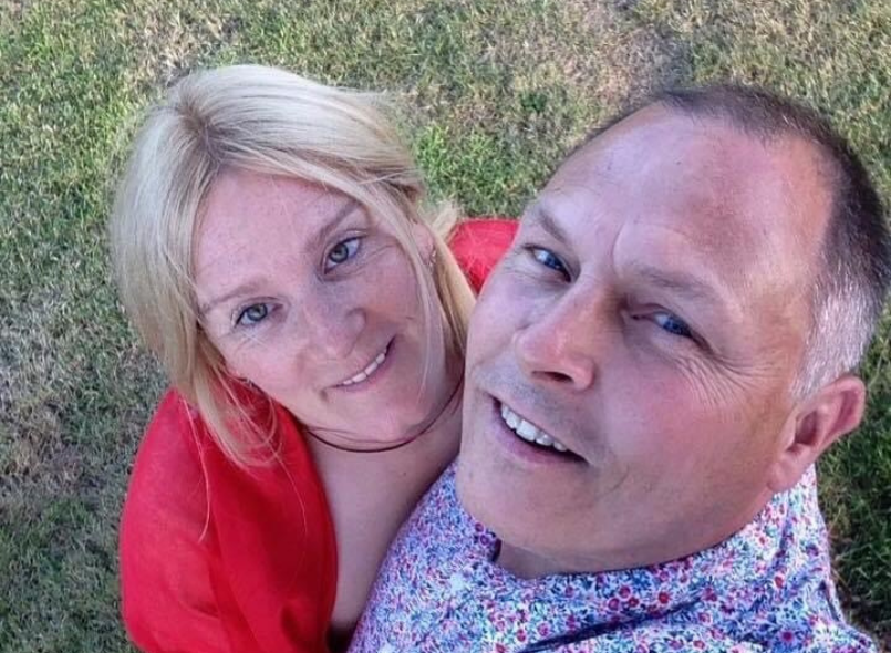 a photo of Zoe and her husband outside smiling to the camera